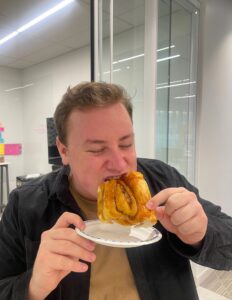 Kyle Lugt bites into a cinnamon bun.