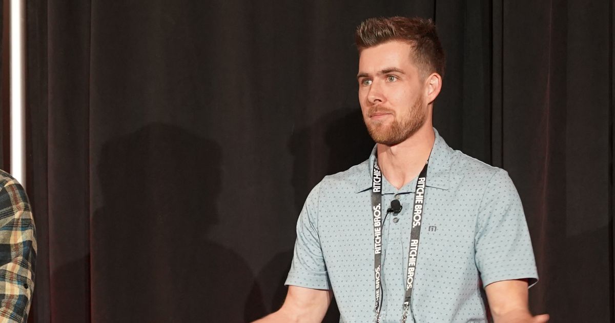 Brady Fahlman sits on the Grain Expo stage.