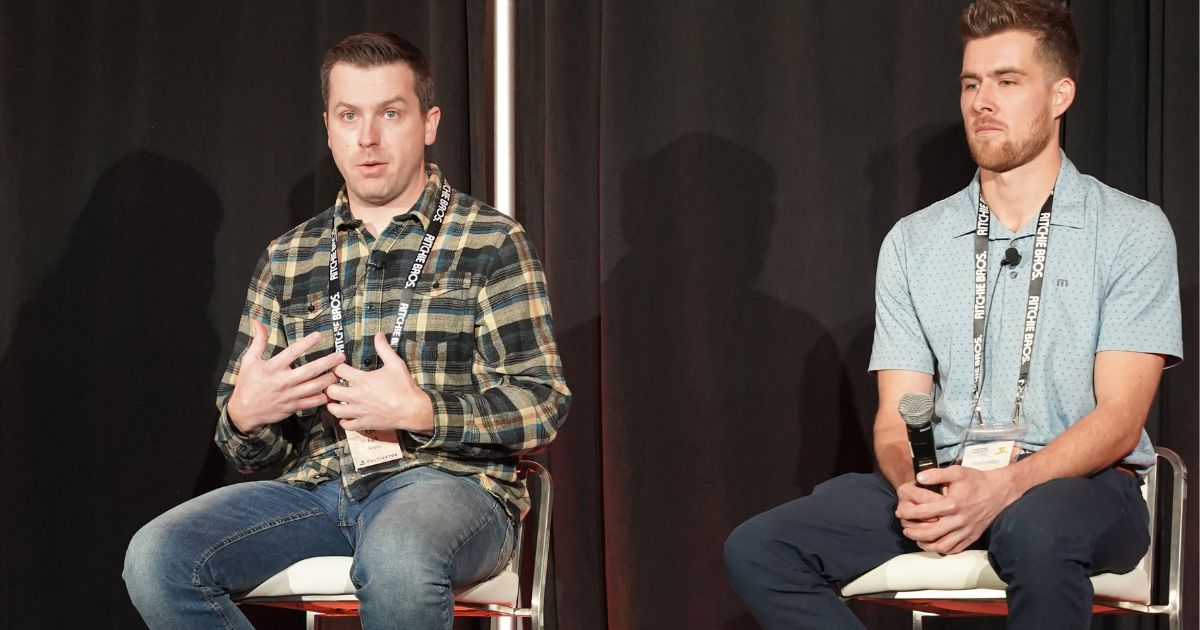 Kyle Folk sitting beside Brady Fahlman on the Grain Expo stage.