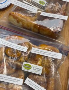 Cinnamon buns are freshly baked from the locally famous Green Spot sit on a counter in pre portioned ziplock bags.