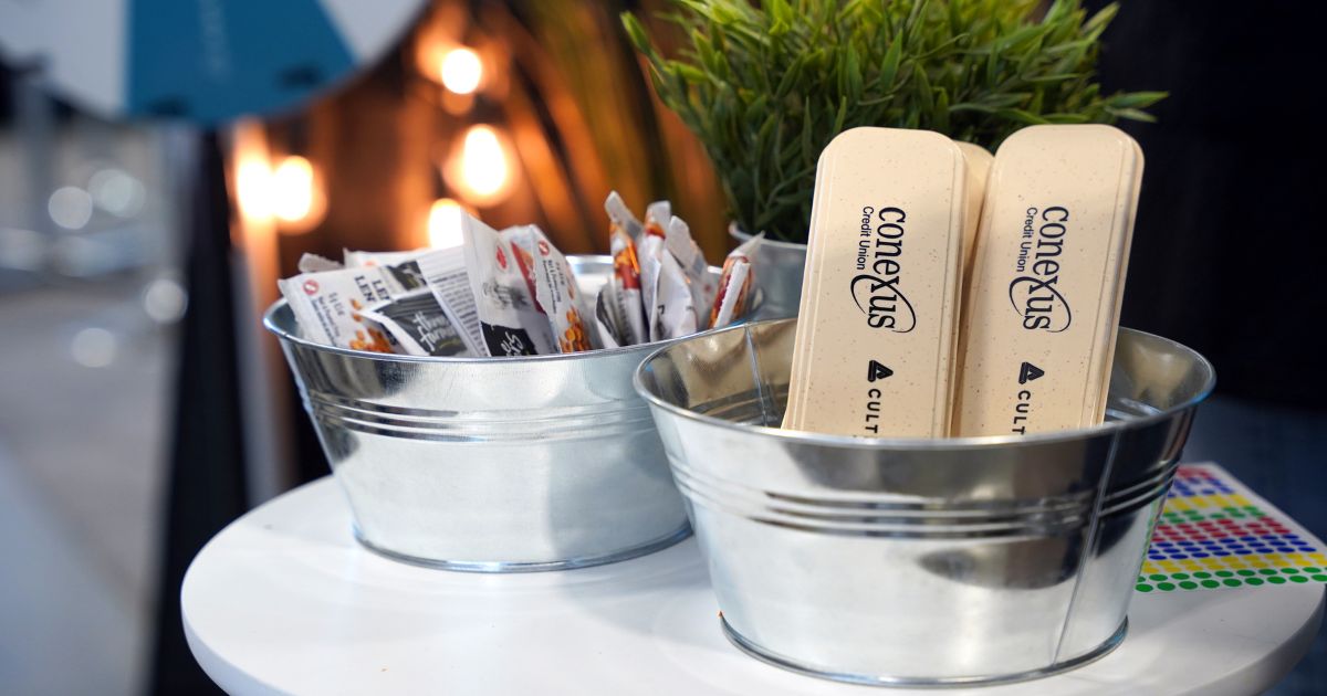 Conexus and Cultivator branded utensil cases sit in a metal tin at the Conexus tradeshow booth as a prize to be claimed.