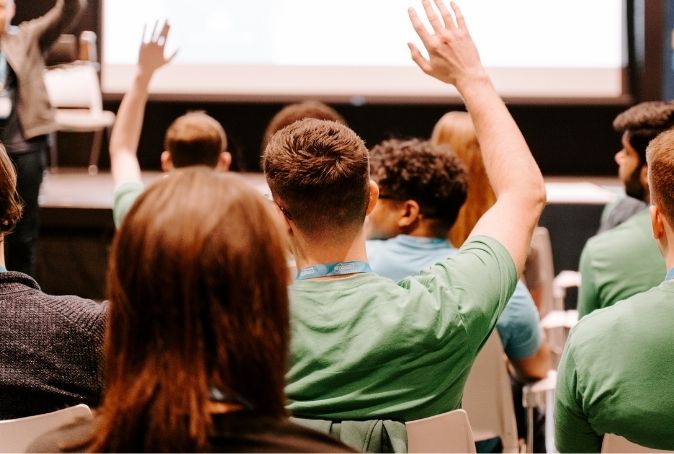 People raising hands at Cultivator event