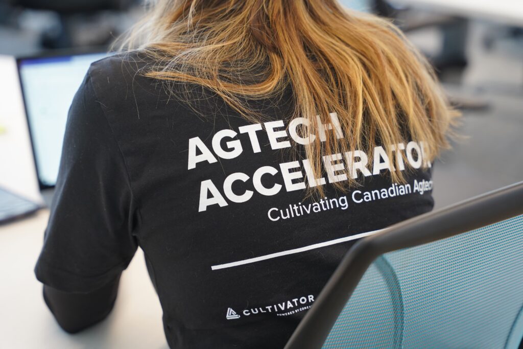 Photo showing the back of a woman's shirt, showing AGTECH ACCELERATOR text