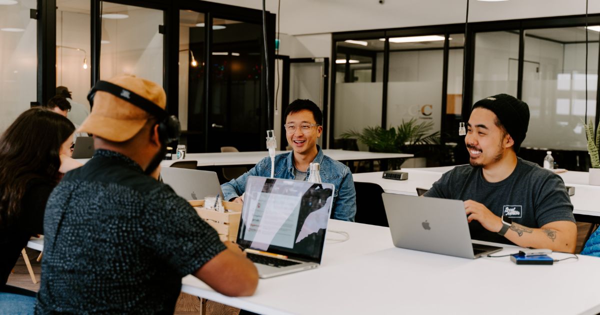 Three Strategy Lab employees sit at a table talking.