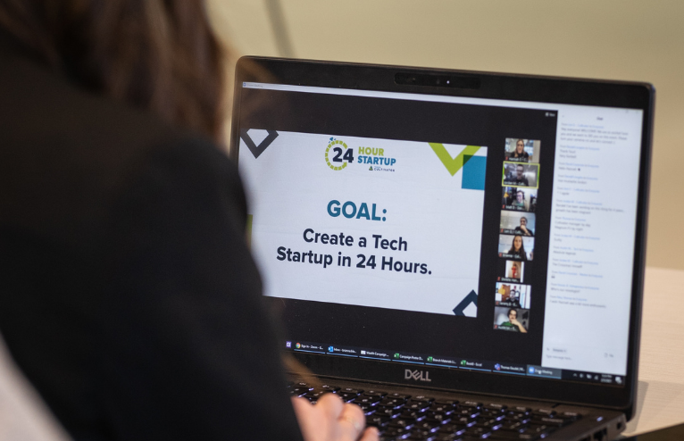 Person looking at computer screen that says create a tech startup in 24 hours