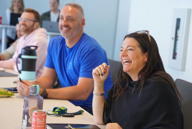 3 founders smile as they listen to a session at Cultivator's Founders' Retreat.