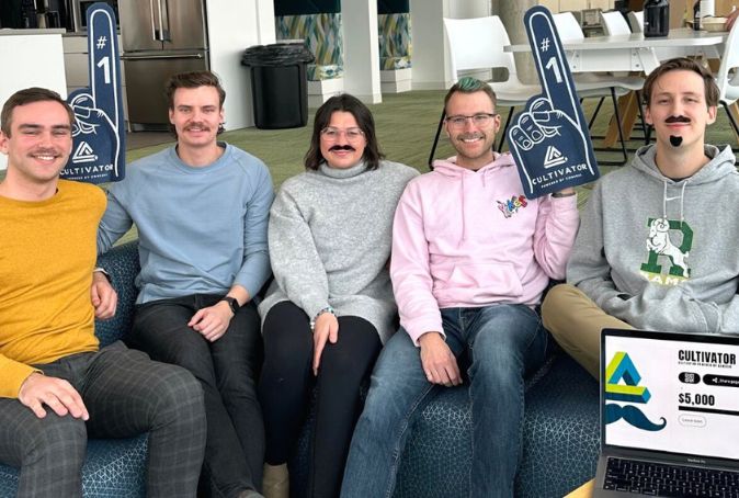 Five people sit on a couch celebrating the success of their Movemeber fundraising campaign.