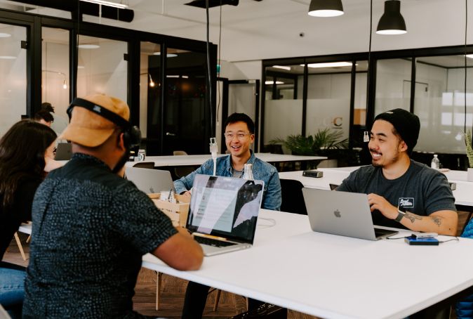 Three Strategy Lab employees sit at a table talking.