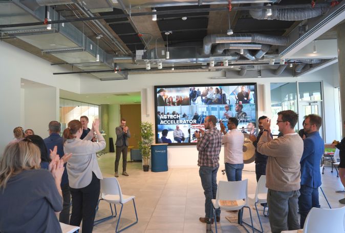 AGTECH ACCELERATOR - COHORT 1 founders stand in a room clapping.