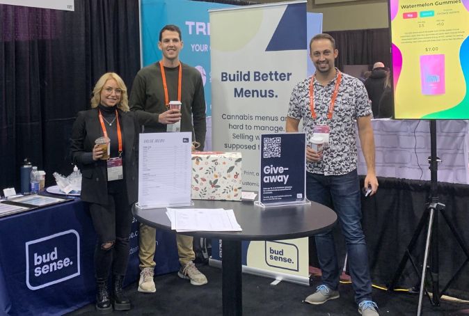 Budsense team at a conference standing in front of their Budsense booth.