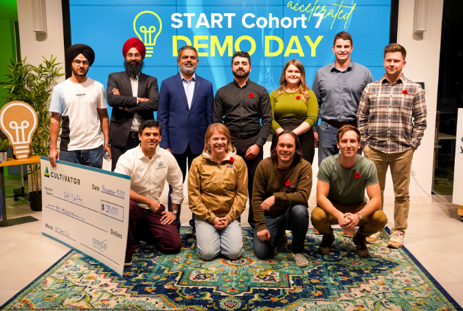 START Cohort 7 founders posing on stage infront of 9 monitor wall