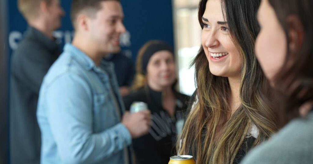 Five individuals mingling and smiling at a Cultivator event.